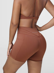 High rise gym shorts for women in Brown - three quarter view showing the pleated detailing.