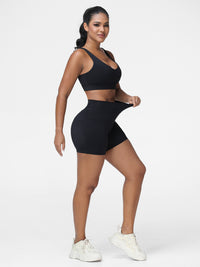 Adjustable strap sports bra and high rise shorts set in Black - three quarter view, two-piece set.