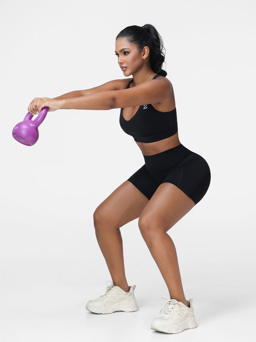 Adjustable strap sports bra and high rise shorts set in Black - side view showing the seamless shorts.