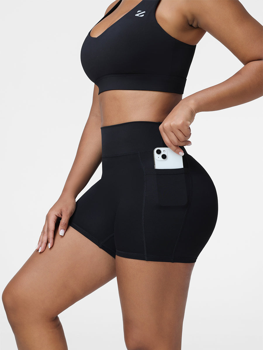 Close-up of the high rise shorts in Black showing the side pocket and seamless waistband.