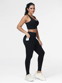 Women's running set in Black - three quarter view showing the zipped side pocket and the phone holder.