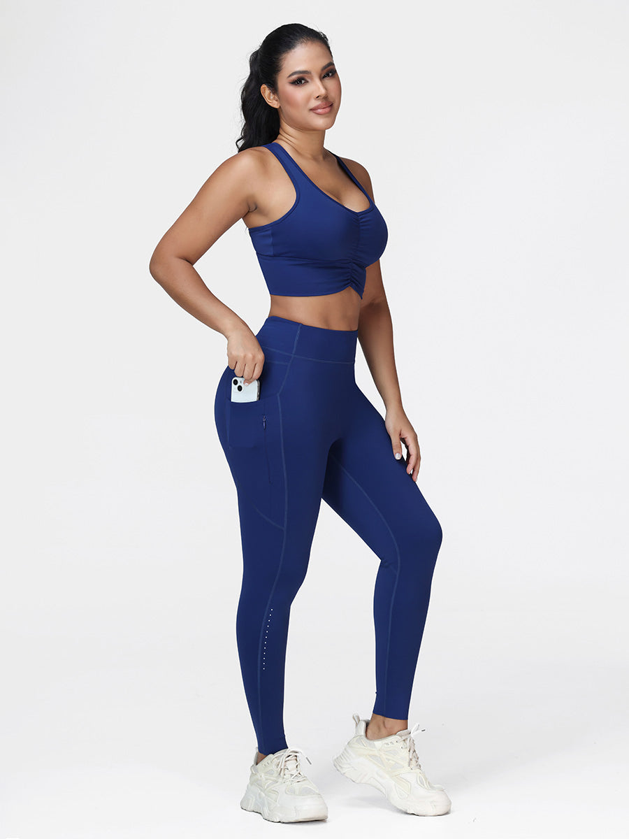 Women's running set in Navy Blue - three quarter view showing the ruched bra and the zipped pocket leggings.