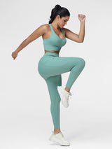 Women's running set in Green - side view showing the contoured fit of the pocket leggings.