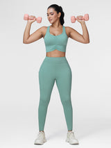 Women's running set in Green - front view showing the ruched sports bra and pocket leggings, two-piece set.