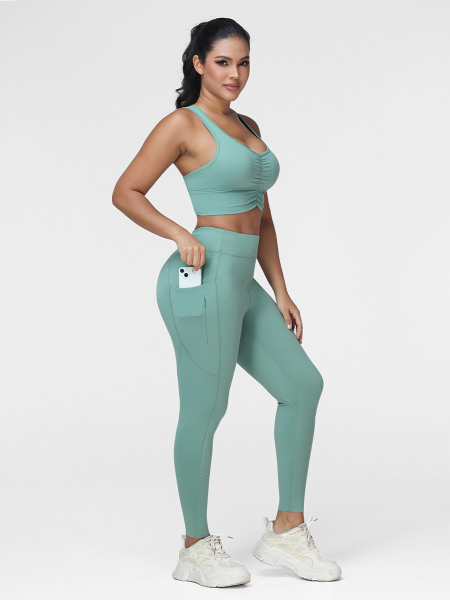 Women's running set in Green - three quarter view showing the ruched bra and the zipped side pocket.