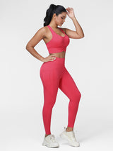 Women's running set in Cranberry Red - three quarter view showing the ruched bra and the high waist leggings.